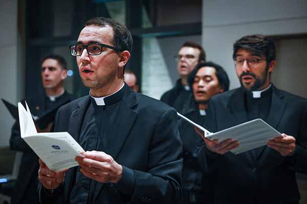 A group of young six Jesuits sing during a service.